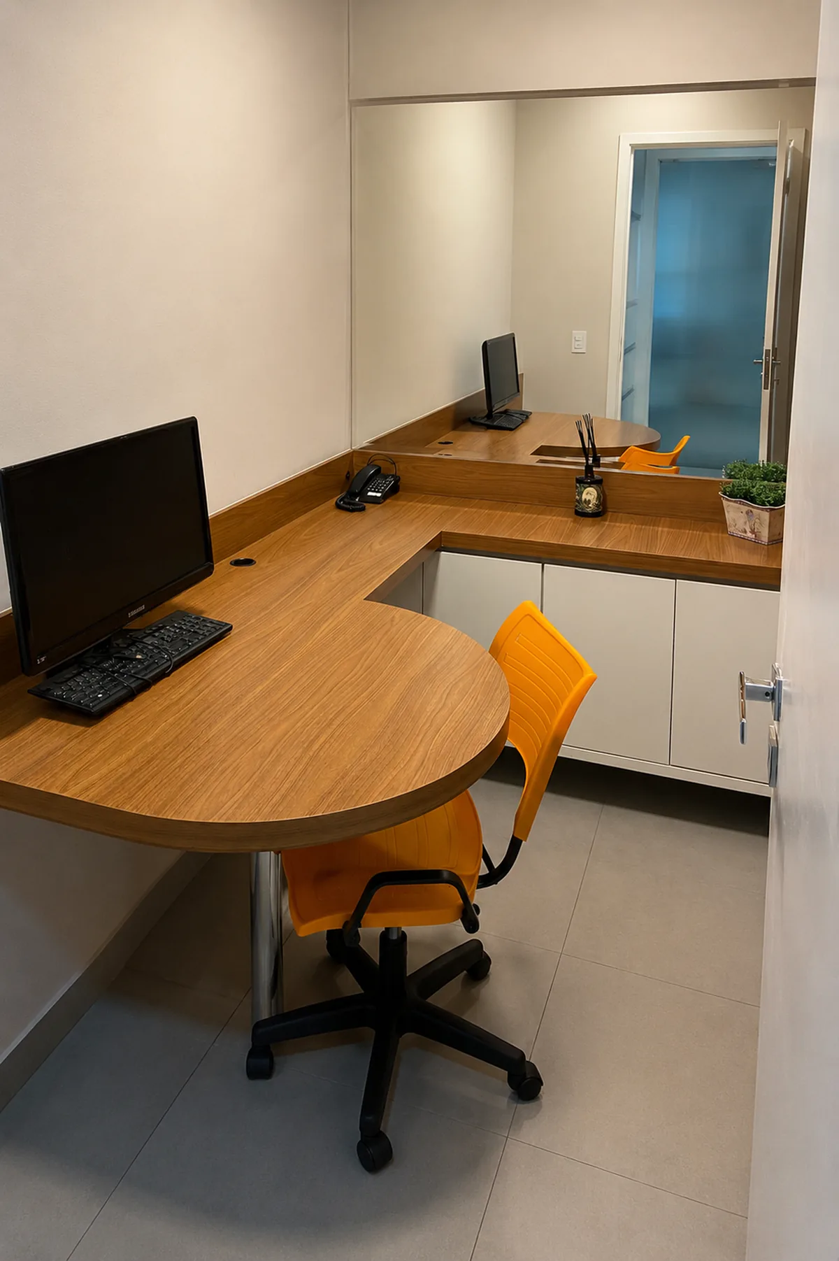 Sala de atendimento e avaliação da Clínica Laser Link, com bancada em madeira e computador